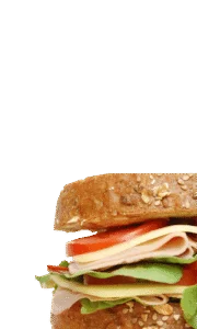 Deli sandwich with ham, turkey, cheese, lettuce and tomato on a whole grain bun